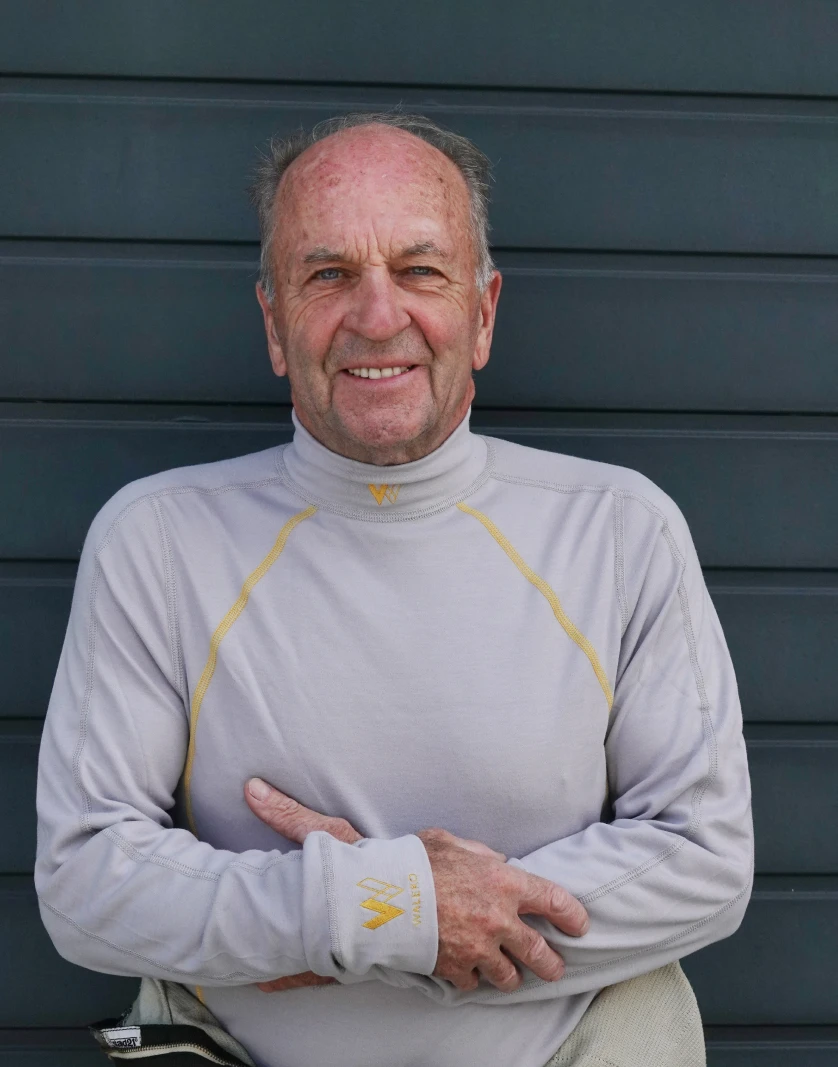Driver smiling in a Walero grey base layer top with yellow stitching